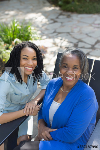 Portrait happy senior mother and adult daughter on patio