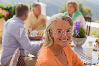 Portrait happy senior woman at patio table with friends