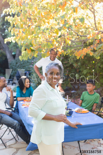 Portrait happy senior woman enjoying lunch with family on autumn patio