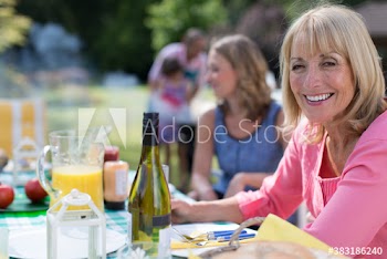 Portrait happy senior woman enjoying lunch with family on patio
