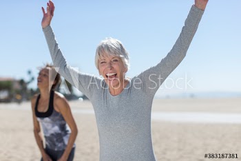 Portrait happy senior woman exercising on sunny beach