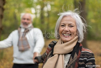 Portrait happy senior woman in autumn park