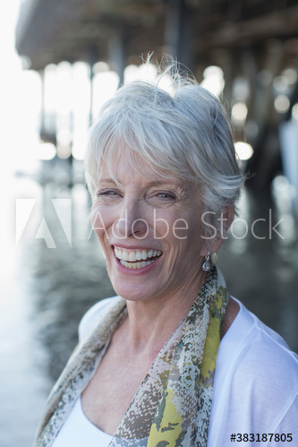 Portrait happy senior woman on beach