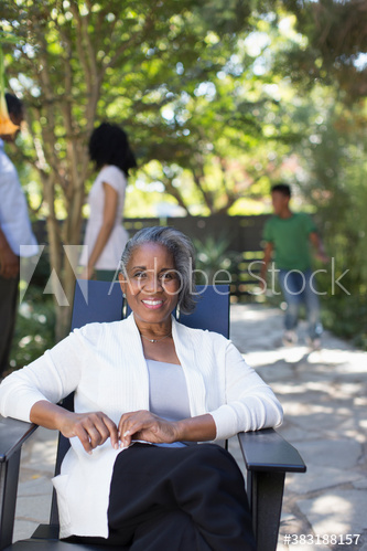 Portrait happy senior woman on patio with family