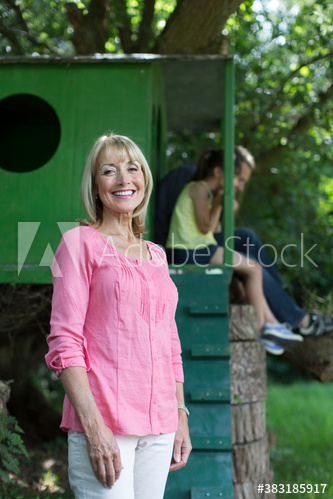 Portrait happy senior woman with family at treehouse