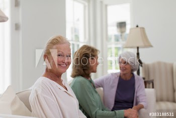 Portrait happy senior woman with friends in living room
