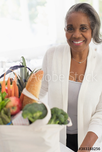 Portrait happy senior woman with groceries