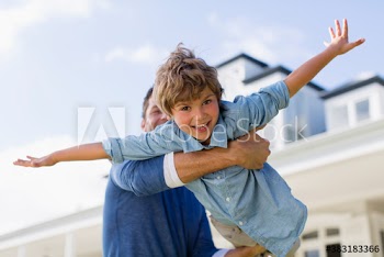 Portrait happy son flying in arms of father