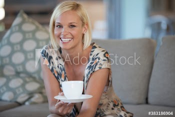 Portrait happy woman drinking coffee on sofa