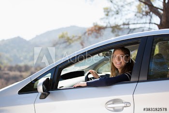 Portrait happy woman driving car