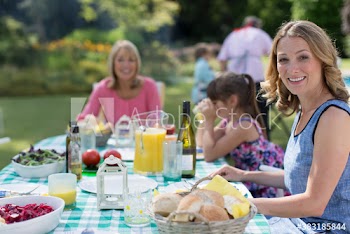 Portrait happy woman enjoying lunch on patio with family