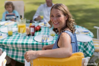 Portrait happy woman enjoying lunch with family in garden