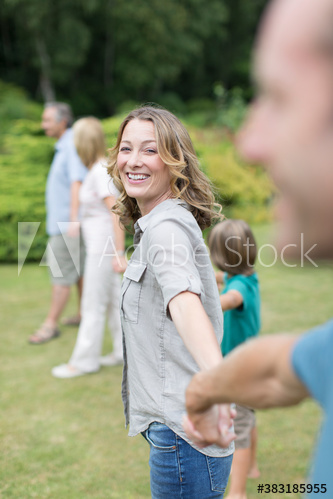 Portrait happy woman holding hands with family in backyard