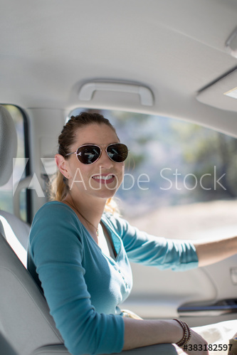 Portrait happy woman in sunglasses driving car