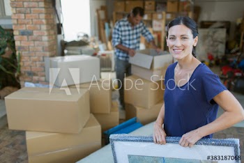 Portrait happy woman moving belongings into garage