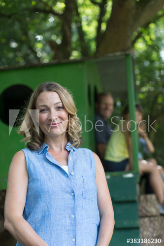 Portrait happy woman with family at treehouse