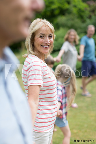 Portrait happy woman with multi-generation family in backyard