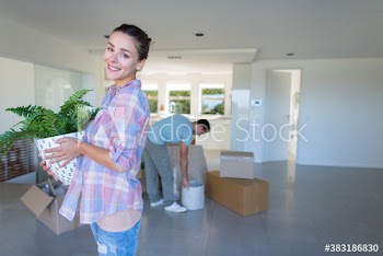 Portrait happy woman with potted plant moving into new house