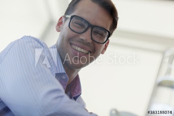 Portrait happy young businessman in eyeglasses
