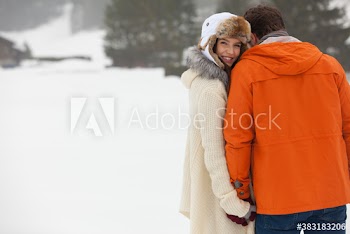 Portrait happy young couple holding hands in snow