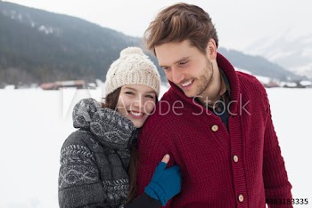 Portrait happy young couple in snowy field