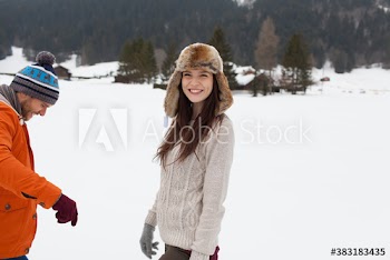 Portrait happy young couple in snowy field