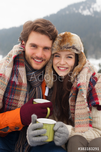 Portrait happy young couple in warm clothing drinking coffee
