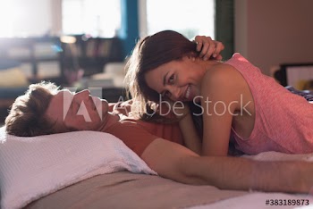 Portrait happy young couple relaxing on bed