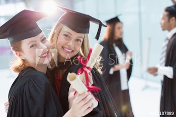 Portrait happy young female college students graduating