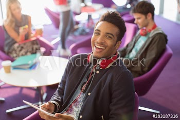 Portrait happy young male college student with digital tablet