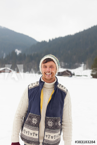 Portrait happy young man in snowy field