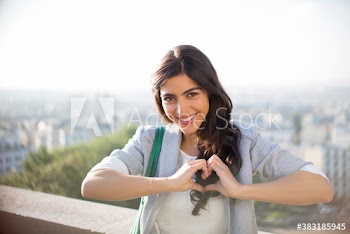Portrait happy young woman gesturing heart-shape, Montmartre, Paris
