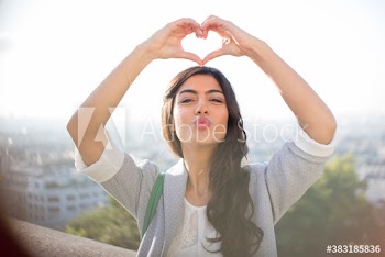 Portrait happy young woman making heart-shape with hands, Montmartre
