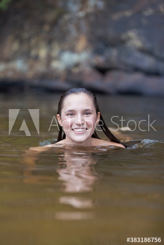 Portrait happy young woman swimming in lake
