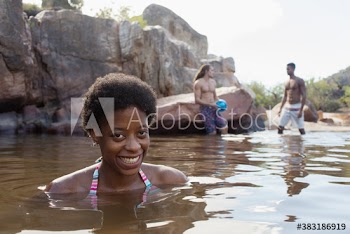 Portrait happy young woman swimming in lake