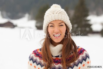 Portrait happy young woman wearing knit hat in snow