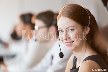 Portrait happy young woman with headset working in call center