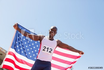 Portrait male track and field athlete celebrating with American flag