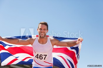 Portrait male track and field athlete celebrating with British flag