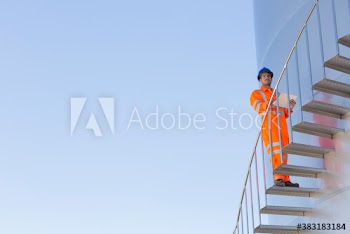 Portrait male worker on storage tank stairs