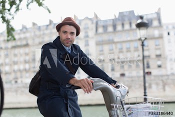 Portrait man riding rented bicycle along Seine River, Paris, France