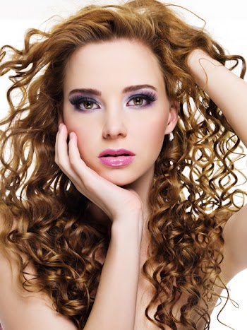 Portrait of a beautiful  woman with  long curly hairs - isolated on white