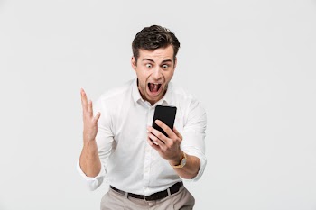 Portrait of a cheery happy man looking at mobile phone Free Photo