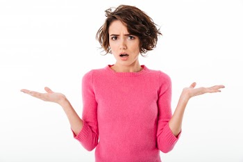 Portrait of a confused young girl shrugging shoulders Free Photo