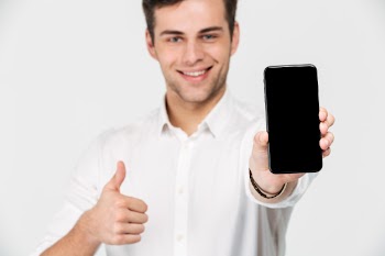 Portrait of a happy smiling man showing blank screen Free Photo