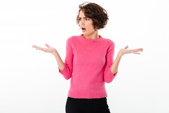 Portrait of a puzzled young girl shrugging shoulders Free Photo