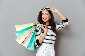 Portrait of a smiling woman holding shopping bags Free Photo