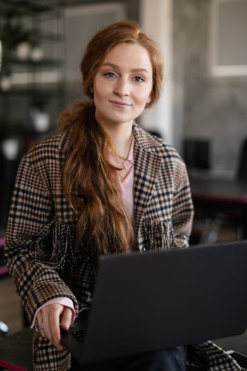 Portrait of a Woman with Red Hair Holding a Laptop · Free Stock Photo