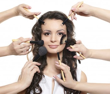 Portrait of beautiful brunette long wavy, curly hair girl with makeup brushes near attractive face, many hands apply make up on woman face isolated on white Free Photo