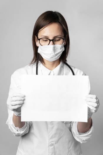 Portrait of doctor with surgical mask holding a sign Free Photo